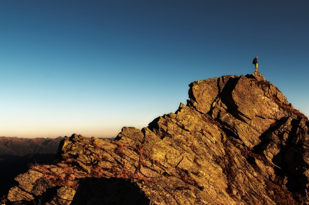 Бесплатное фото Человек, стоящий на вершине скалы в дневное время
