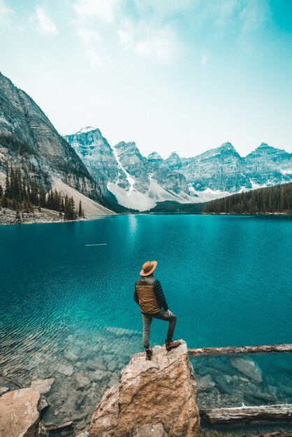 Man standing on rock near lake