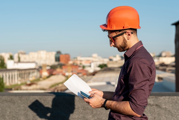 Man standing on rooftop with phone in hand