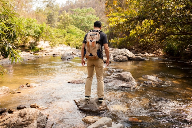 Man standing on stone at river