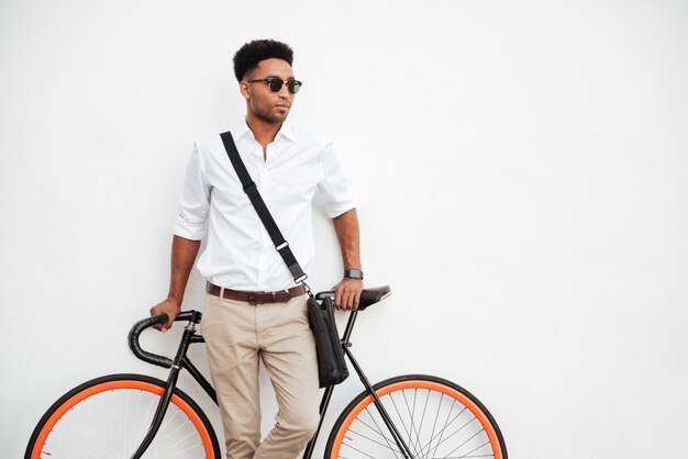 Man standing on white wall outdoors looking aside.