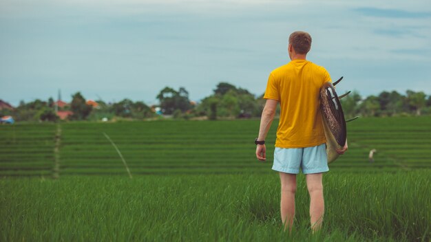 A man stands in a rice field.