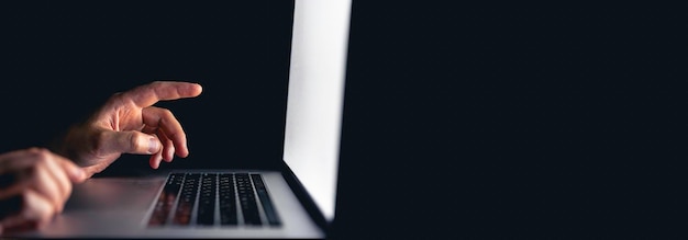 Free photo a man stares intently at a computer screen in the dark at night copy space