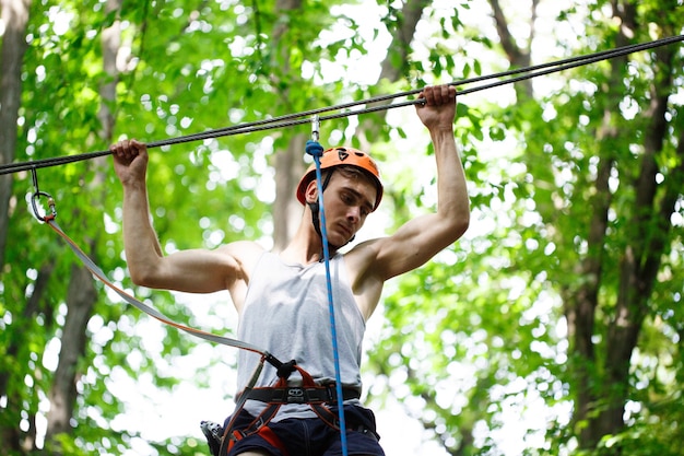 Free photo man steps on the rope hanging in the air