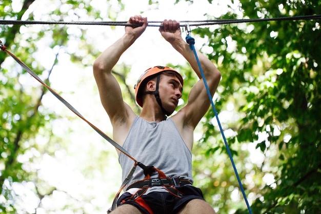 Free photo man steps on the rope hanging in the air