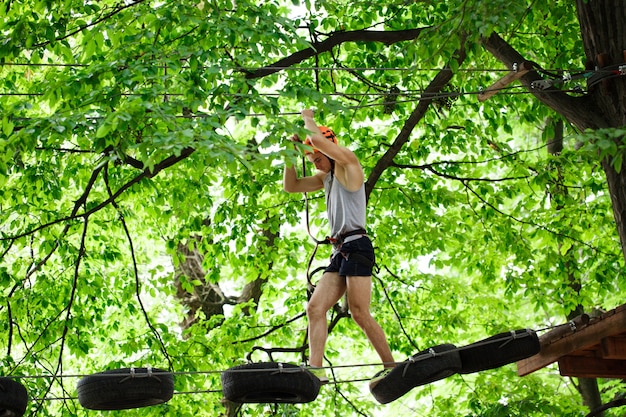 Man steps on the wooden boards hanging in the air