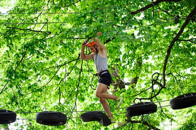 Man steps on the wooden boards hanging in the air