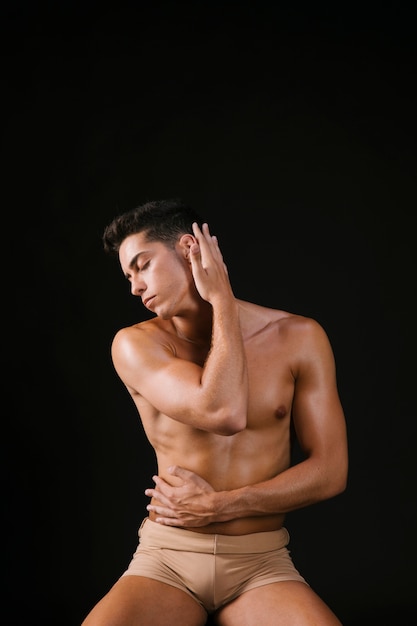 Man straightening hair with hand and hugging body 