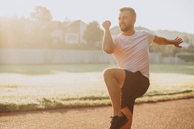 スタジアムでのトレーニングの前にストレッチする男