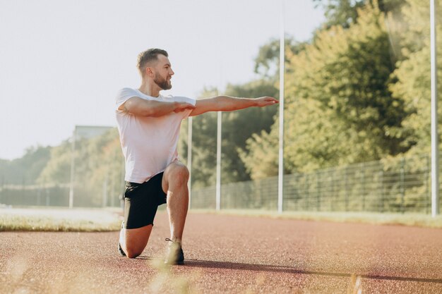 Man stretching before workout at the stadium