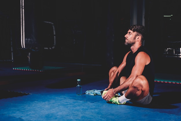 Foto gratuita uomo che si estende in palestra