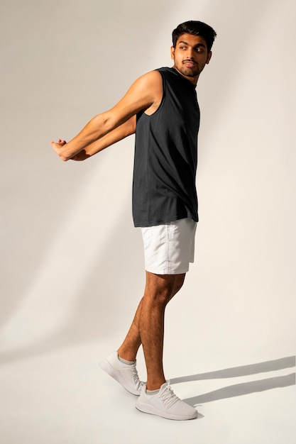 Man stretching in navy tank top and shorts sportswear apparel