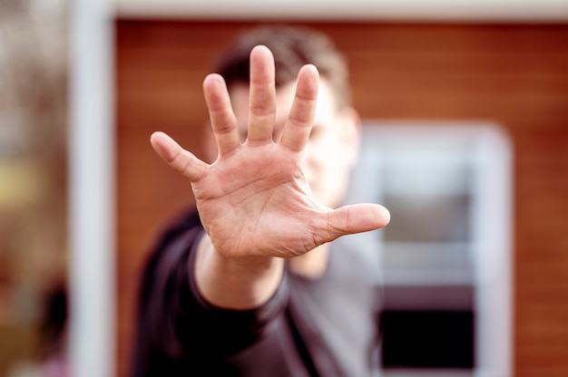 Free photo man stretching out hand over blurred house