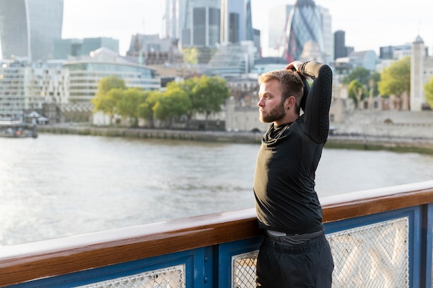 Man stretching outdoors medium shot