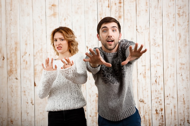 Man stretching  smiling girl refuse over wooden wall