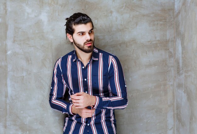 Man in striped shirt closing his buttonier.