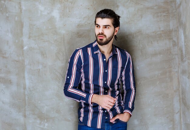 Man in striped shirt looks confused and thoughtful.