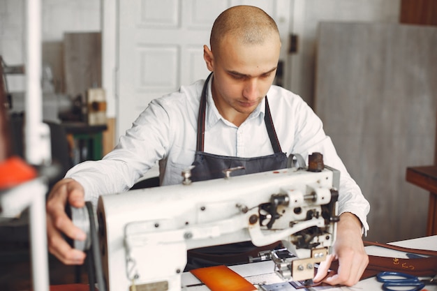 Free photo man in a studio creates leather ware