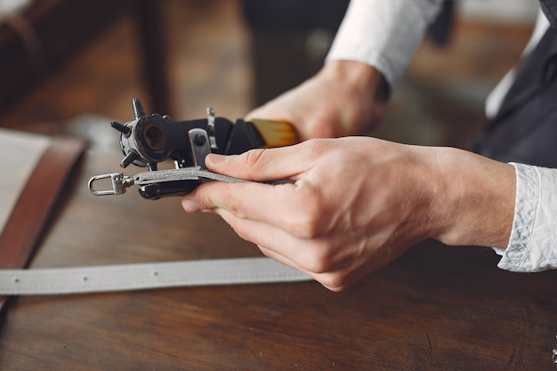 Free photo man in a studio creates leather ware