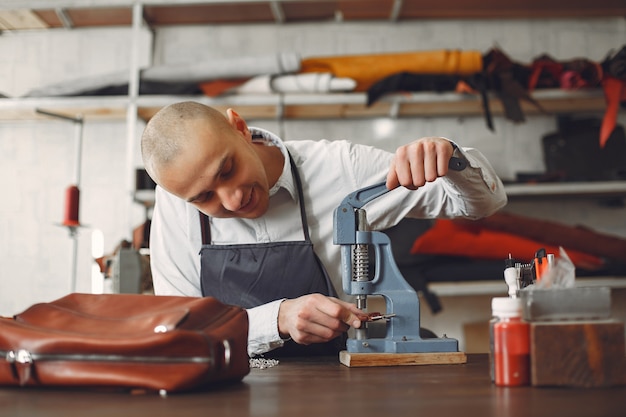 スタジオの男は革製品を作成します