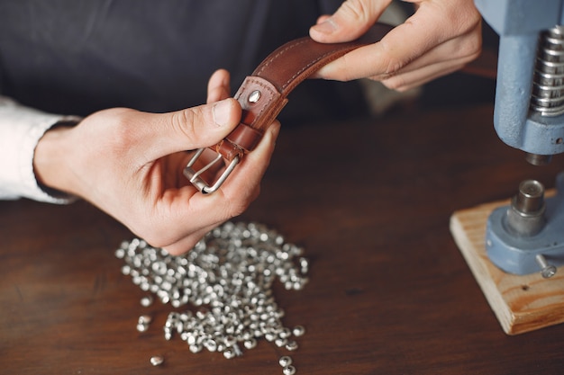 Free photo man in a studio creates leather ware