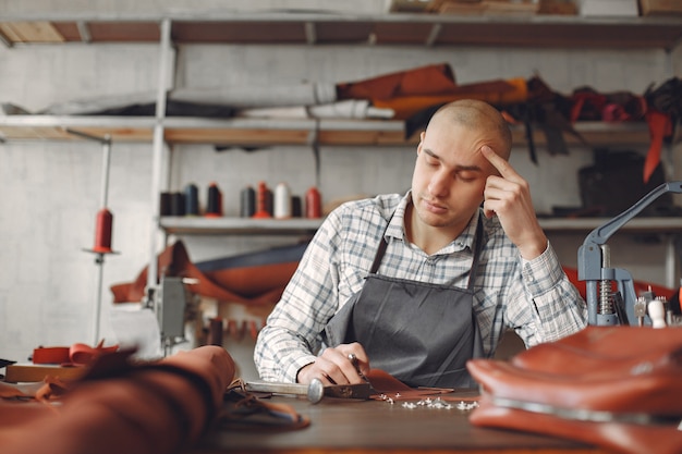 Free photo man in a studio creates leather ware