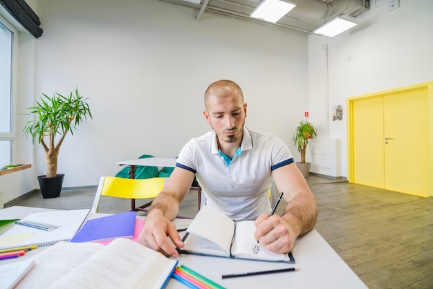 部屋で勉強している男