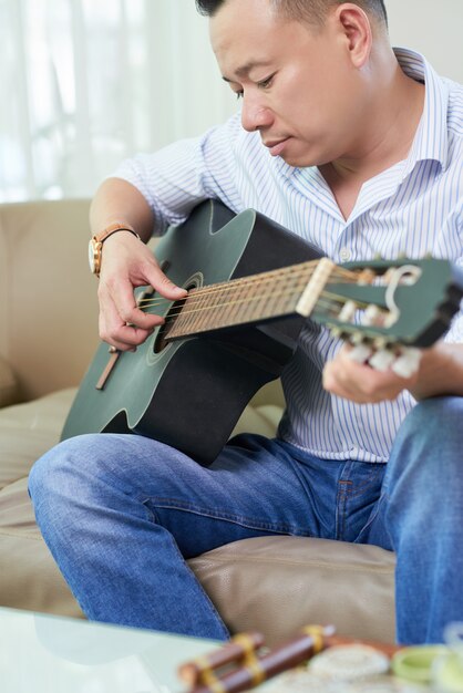 Man studying to play guitar