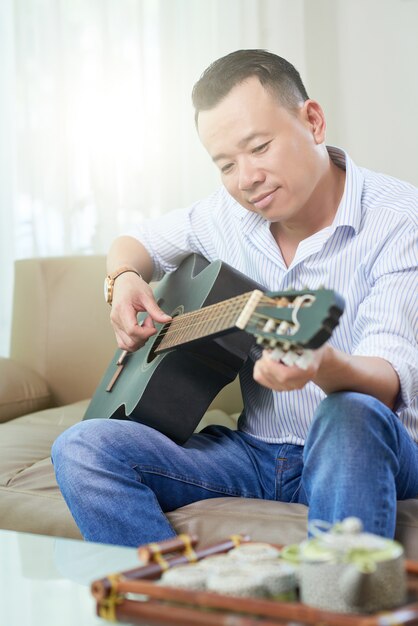 Man studying to play guitar