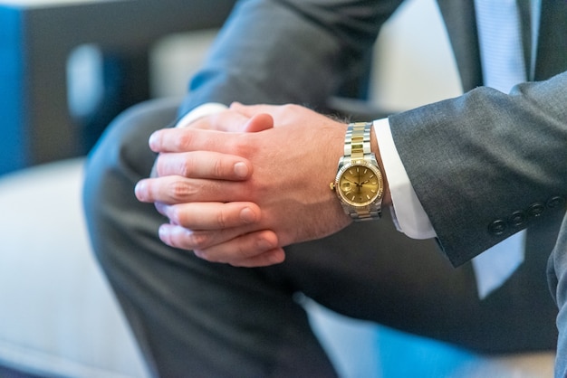 man in suit clasping his hands