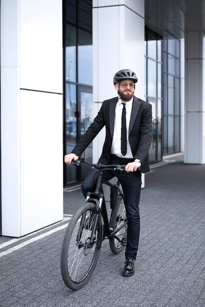 Free photo man in suit cycling to work full shot