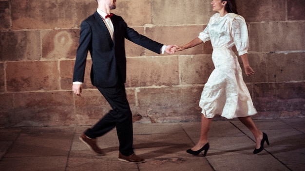 Man in suit dancing with woman in street 