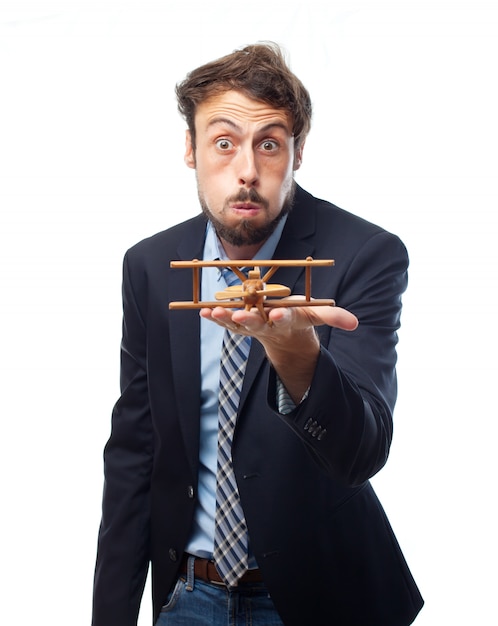 Free photo man in suit playing with a wooden plane