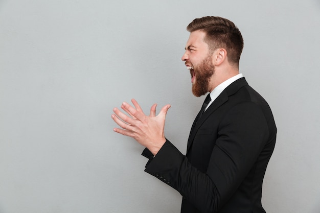Man in suit shouting and gesturing with hands