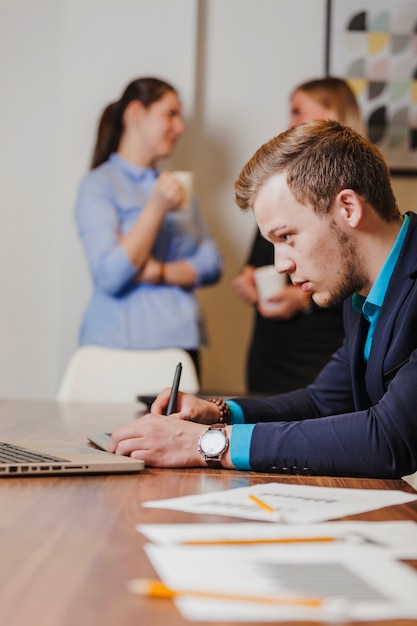 Man in suit sitting at desk drawing