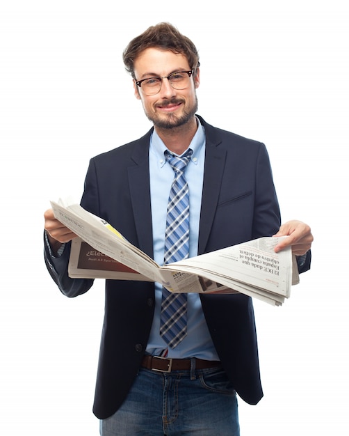 Man in suit smiling while reading a newspaper