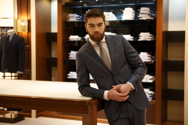 Man in suit standing near the table shop