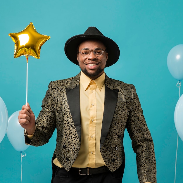 Free photo man in suit and sunglasses at party with balloon