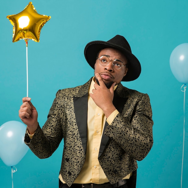 Man in suit and sunglasses at party with balloon