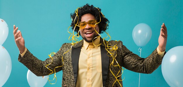 Free photo man in suit and sunglasses at party with balloons