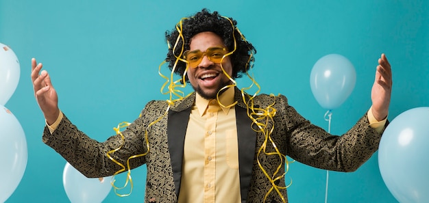 Man in suit and sunglasses at party with balloons