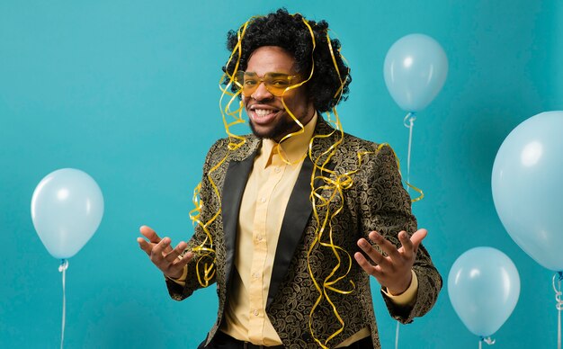 Man in suit and sunglasses at party with balloons