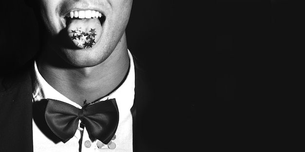 Man in suit with spangles on tongue 