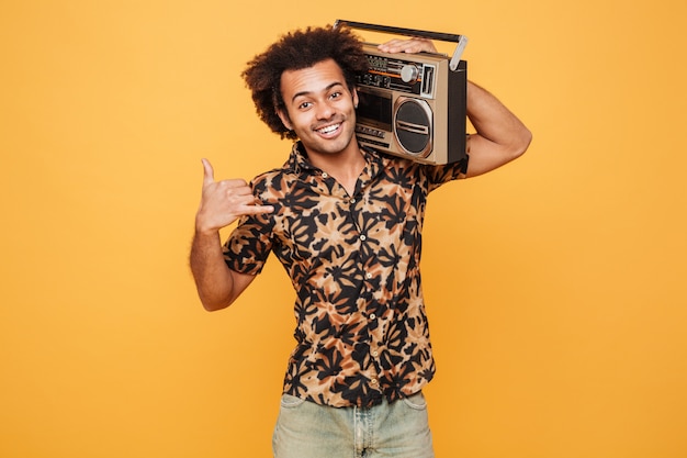 Free photo man in summer clothes holding boombox on his shoulder