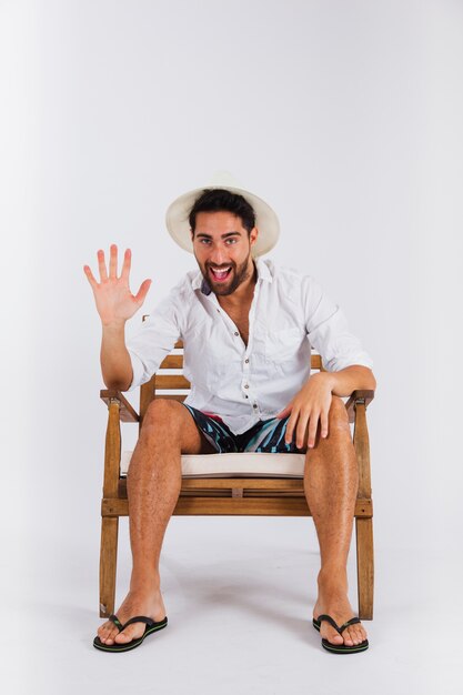 Man in summer wear on chair showing palm of the hand