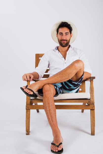 Мужчина в летней одежде сидит на стуле
