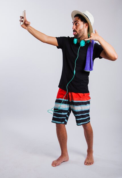 Man in summer wear taking selfie making signs with hand