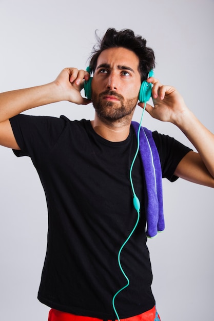 Man in summer wear trying out headphones