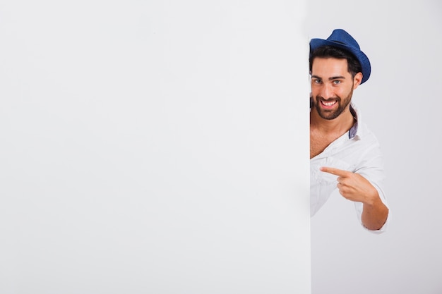 Man in summer wear behind wall