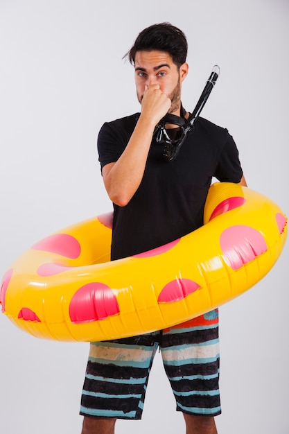Man in summer wear with floating tube holding nose